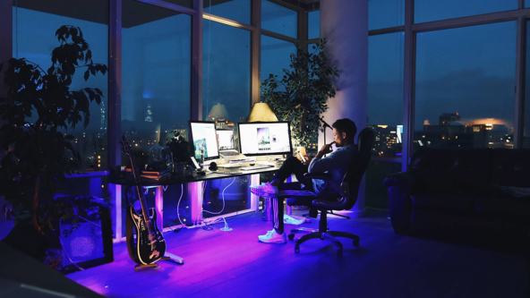 Man on computer in purple light in dark