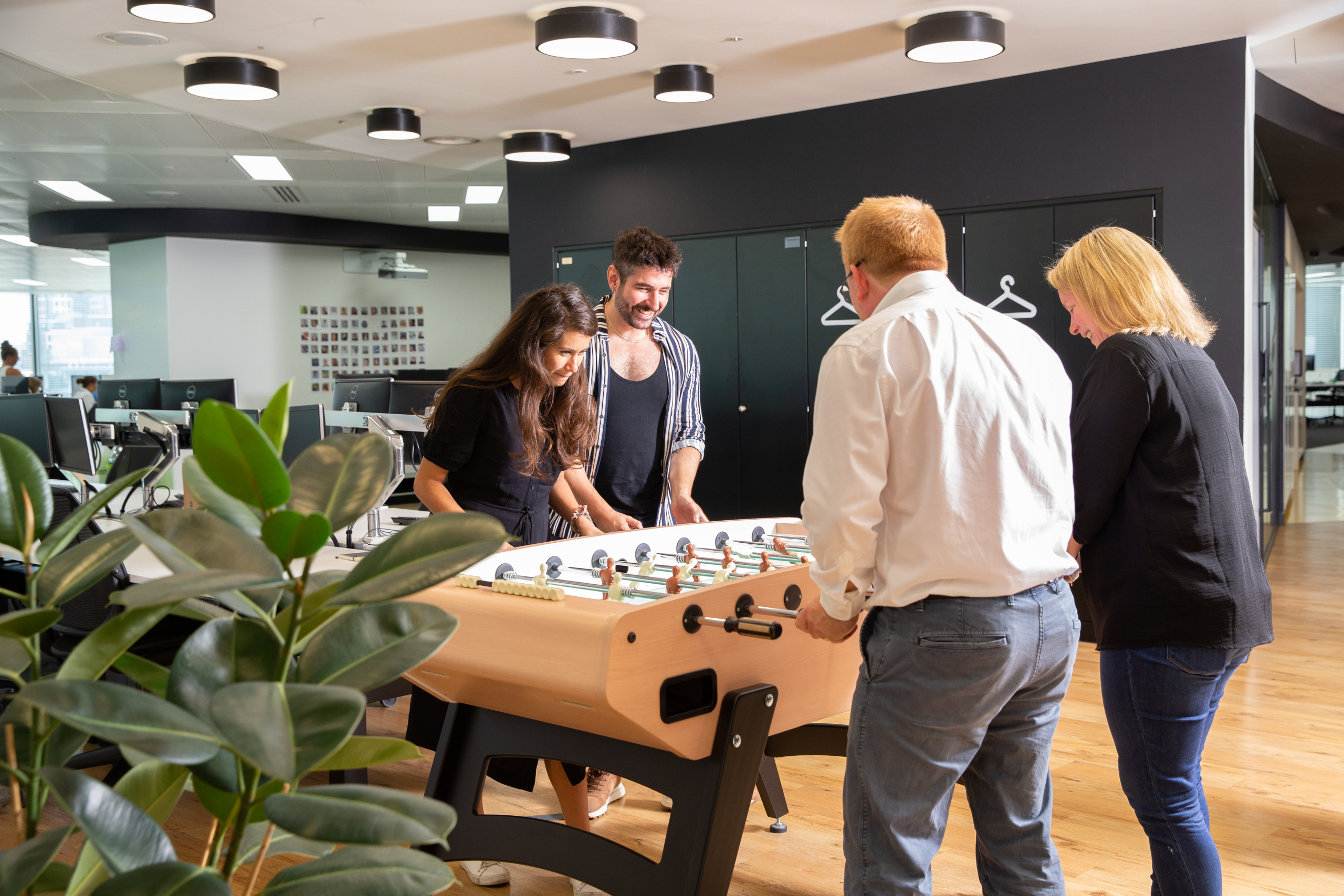 A group of people playing foosball 